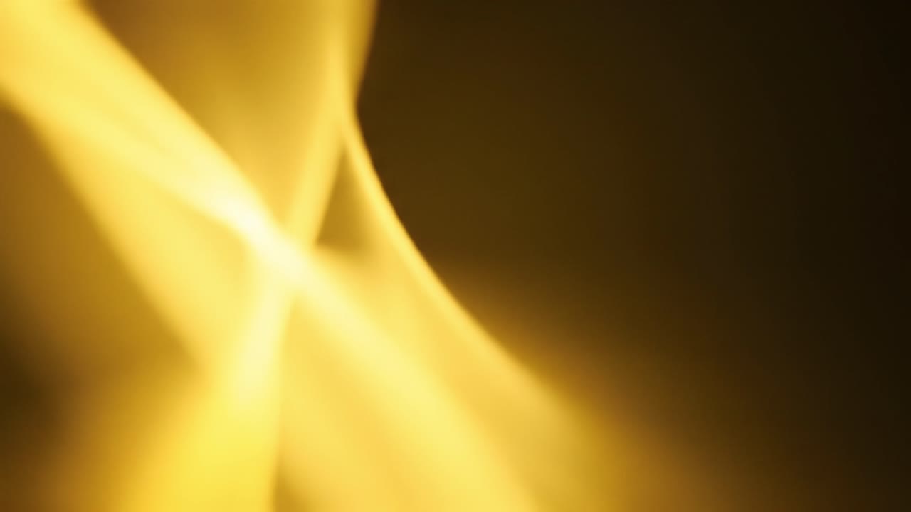 Soft, flowing lines of golden light weave through a dark background, creating an abstract design that evokes a sense of warmth and tranquility, perfect for a calming experience.
