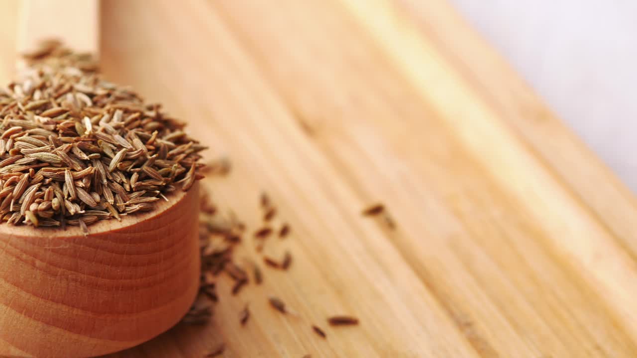 Cumin seeds on spoon on table