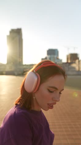 woman listening to music in the city at sunset