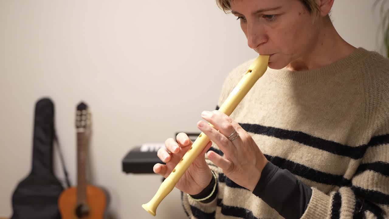 Donna che suona un flauto dolce in un ambiente interno
