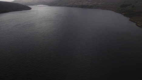 aerial drone footage tilt up reveal of mountain stac pollaidh with clouds on the top in scottish highlands