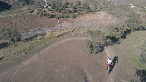 Aerial-static-shot-of-a-dusty-motocross-track-in-Malaga-spain-at-a-highway-while-a-motocross-rider-makes-a-turn