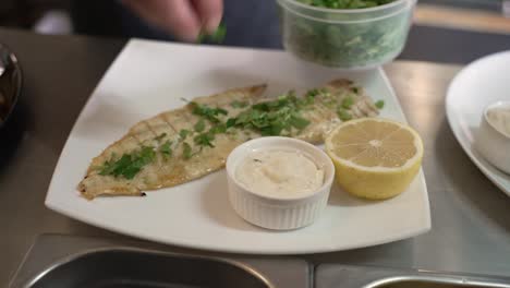 delightful grilled fish served with zesty lemon and creamy sauce for a perfect meal experience