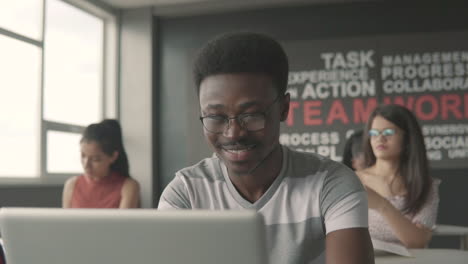 black student boy typing on a laptop