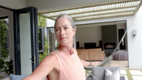 Caucasian-woman-with-grey-hair-standing-on-balcony