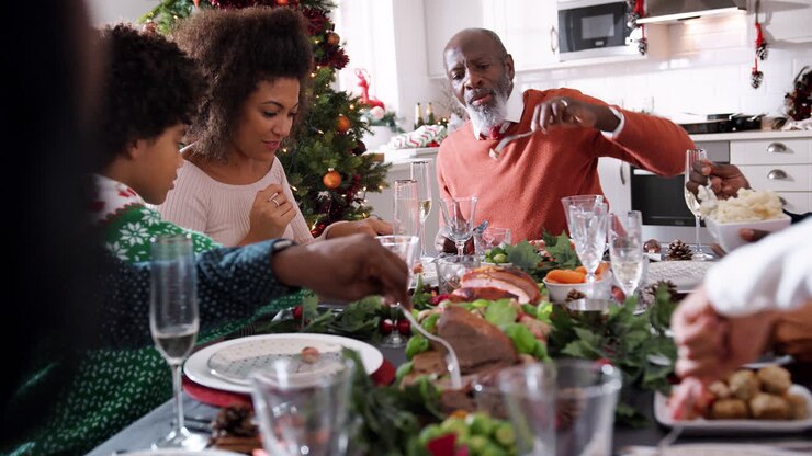 Black multi generation family serving themselves food at their Christmas dinner table