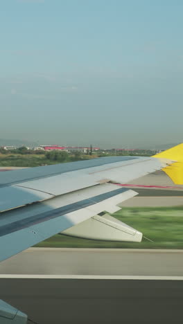 view from a plane window during takeoff from airport in shot in vertical