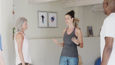 Grupo-Diverso-Enfocado-De-Personas-Mayores-Escuchando-A-Una-Entrenadora-De-Pilates,-Inalterada,-En-Cámara-Lenta