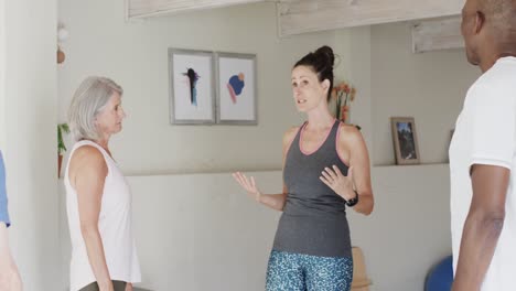 grupo diverso de ancianos escuchando a una entrenadora de pilates, sin alteración, en cámara lenta