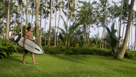 man walking and holding surfboard