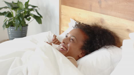woman resting in bed, covered with white blanket, relaxing at home