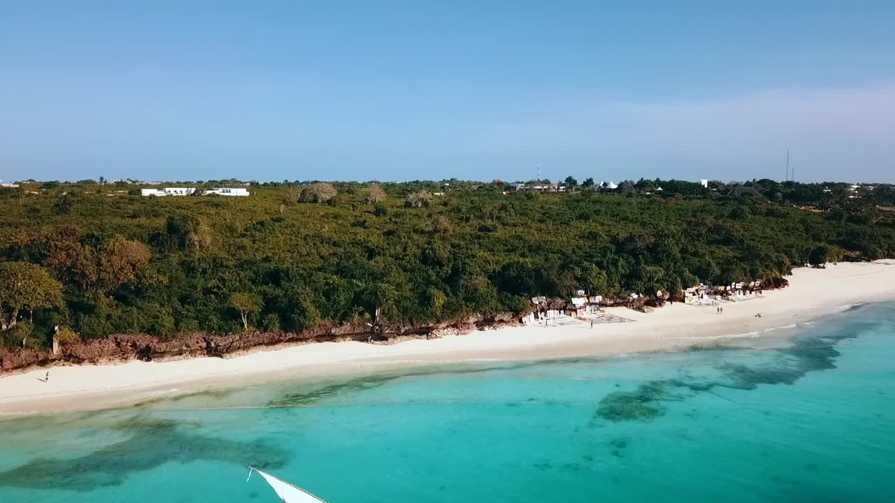 100万ドルの空中飛行クレーンドローンショット、透き通ったターコイズブルーの水の楽園ドリームビーチザンジバル、アフリカ2019に白い帆を持つ海賊セーリングブーツのショット