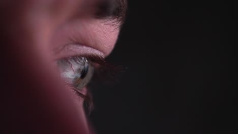 reflection of screen on person's blue green eye in dark room 18