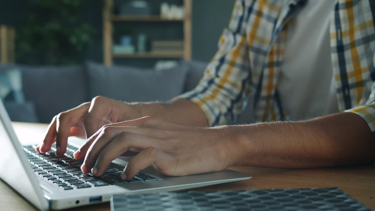 persona escribiendo en una computadora portátil en casa