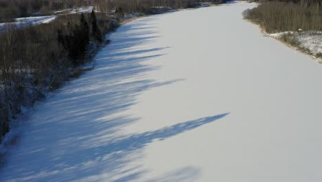 Landschaft-Des-Zugefrorenen-Flusses-Durch-Struppige-Kahle-Bäume-An-Sonnigen-Tagen-Im-Winter