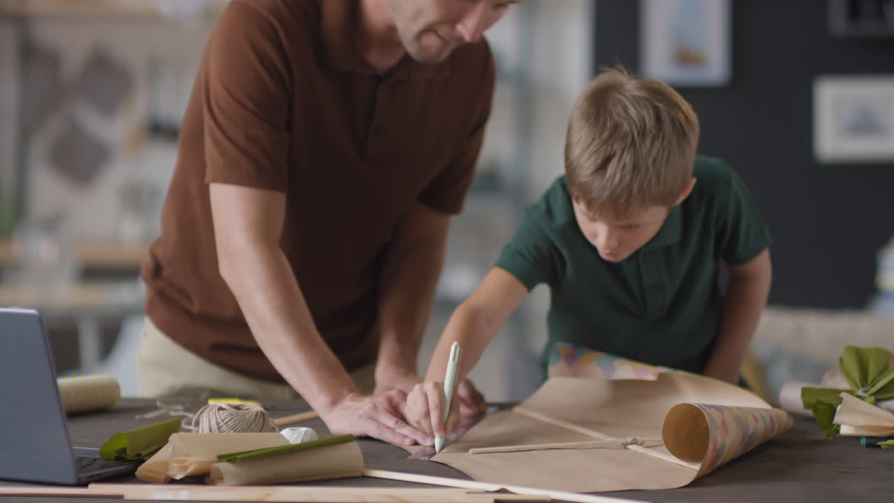 padre e hijo haciendo una cometa juntos