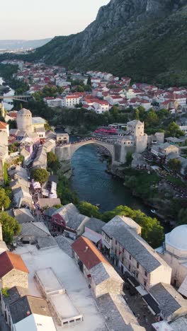 the mostar bridge in bosnia, showcasing the river and surrounding area, aerial vertical view