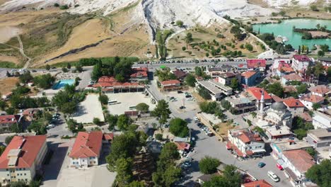 Luftschwenkaufnahme-Von-Wohngebäuden-In-Einem-Pamukkale-In-Der-Türkei,-Das-Für-Seine-Weißen,-Mineralreichen-Berge-Und-Thermalbecken-Bekannt-Ist