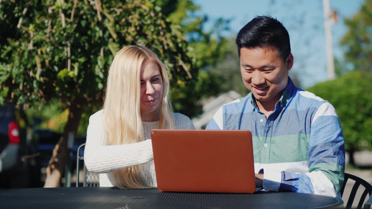 남자와 여자는 야외에서 노트북으로 작업