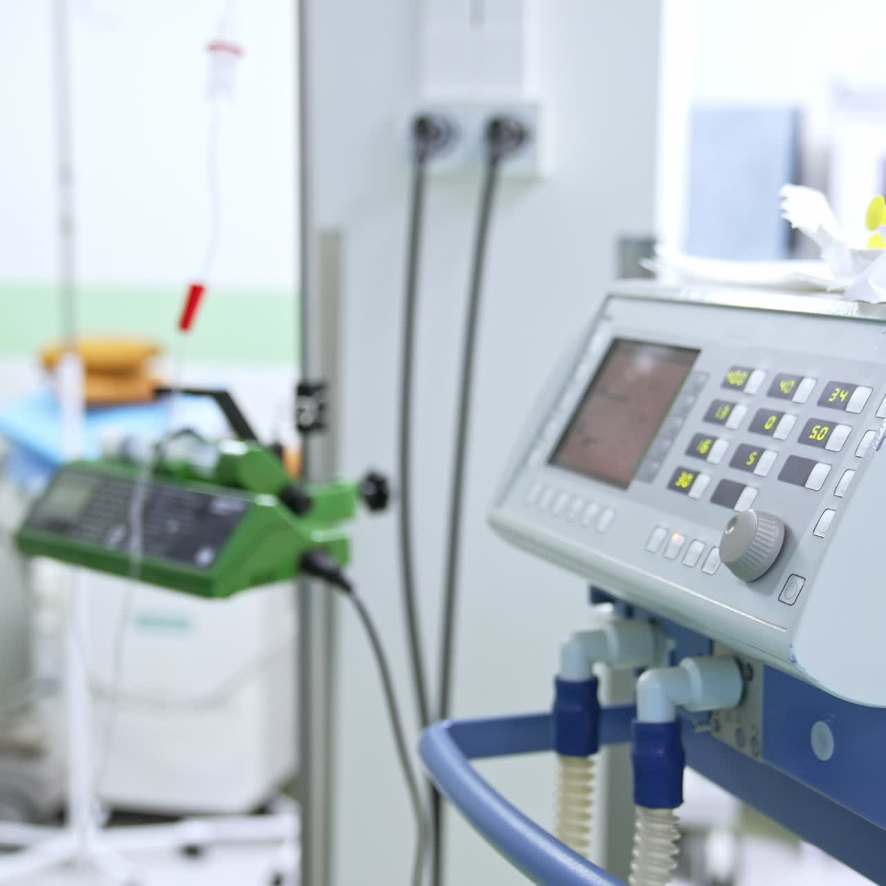 Diverse equipment necessary for surgical operations in modern clinics. Medic in blue uniform walking at backdrop in blur