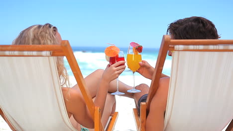 Couple-on-deck-chairs-drinking-cocktails