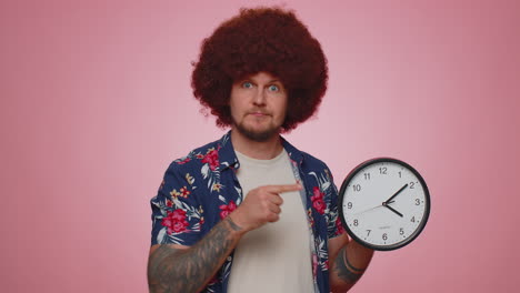 bearded young man showing time on clock watch, ok, thumb up, approve, pointing finger at camera