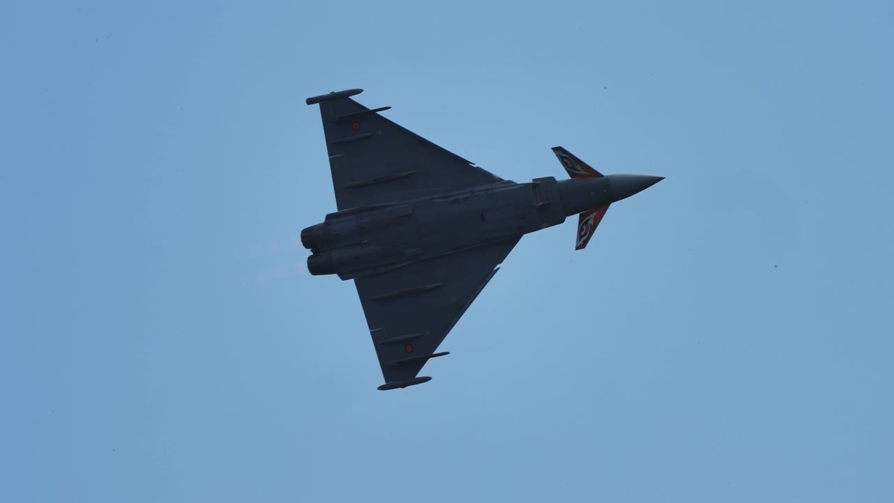 Military aircraft turning in the blue sky