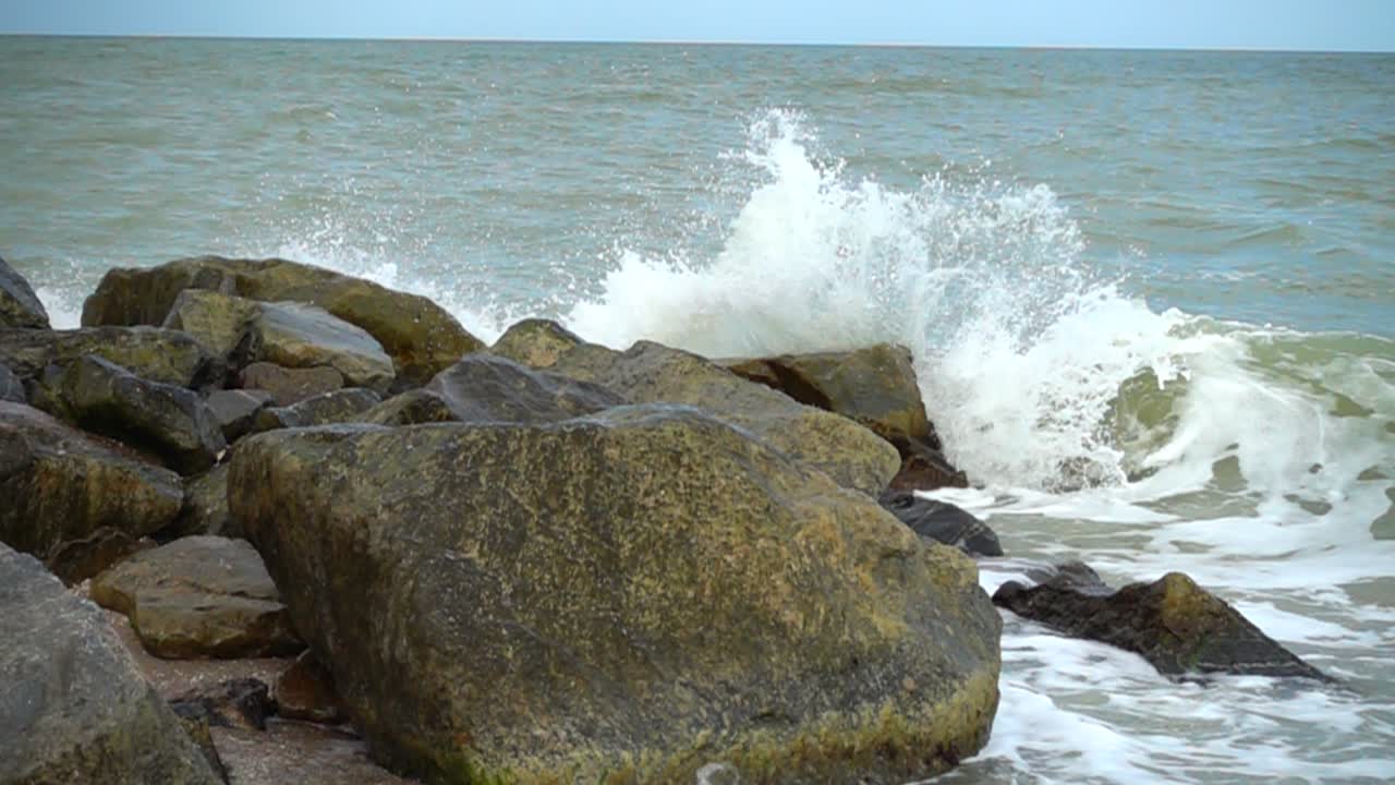 Havbølger slår mod sten. Optagelse ved strandkanten. Slow motion