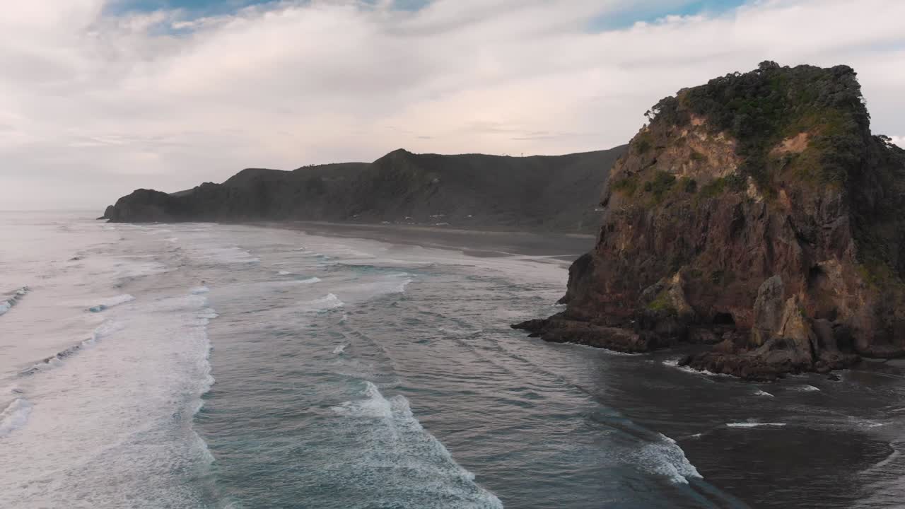 Lento surffiaaltojen yli Piha Beachilla, Uudessa-Seelannissa.