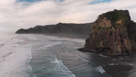 flying over surfing ocean waves at piha beach, new zealand