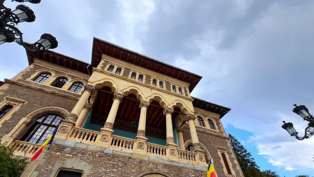 Busteni, Romania, 17 July 2025: Approaching the beautiful façade of Cantacuzino Castle, Busteni, Romania. Low angle view. Lovely plants and lanterns in front of the building