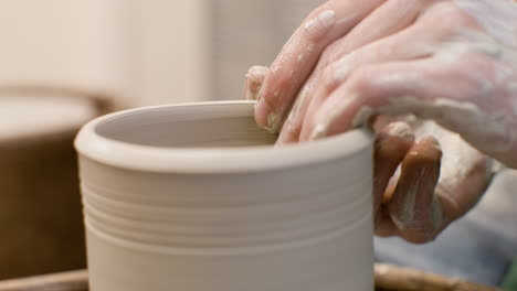 close up view of hands of a clerk modeling ceramic piece on a potter wheel in a workshop 3