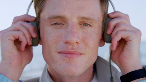 cara, auriculares de música y hombre en la playa escuchando