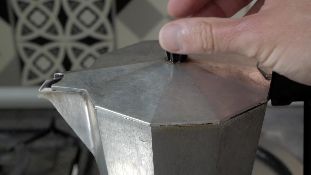 Open stovetop coffee maker with rustic kitchen background