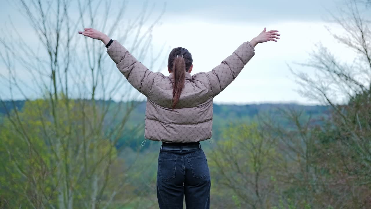 Tranquil scene of woman embracing wilderness surrounded by spring forest, 4K