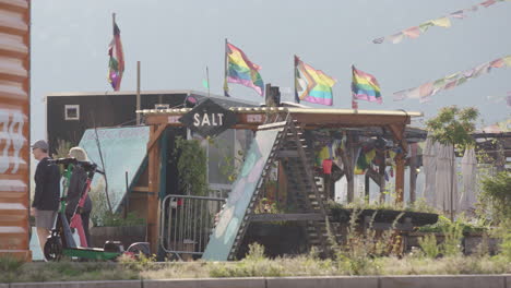 rainbow and tibetan prayer flags fly above salt arts and music venue, oslo