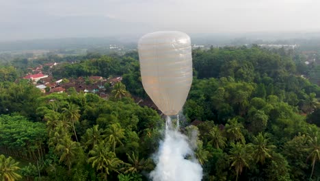 globo aerostático con petardos se elevan sobre el paisaje tropical de java indonesia