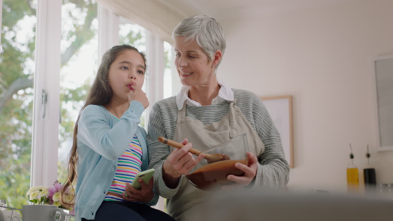 행복한 작은 소녀가 부 ⁇ 에서 할머니를 도와 요리하고 할머니와 함께 재료를 맛보고 집에서 조리법을 준비합니다.
