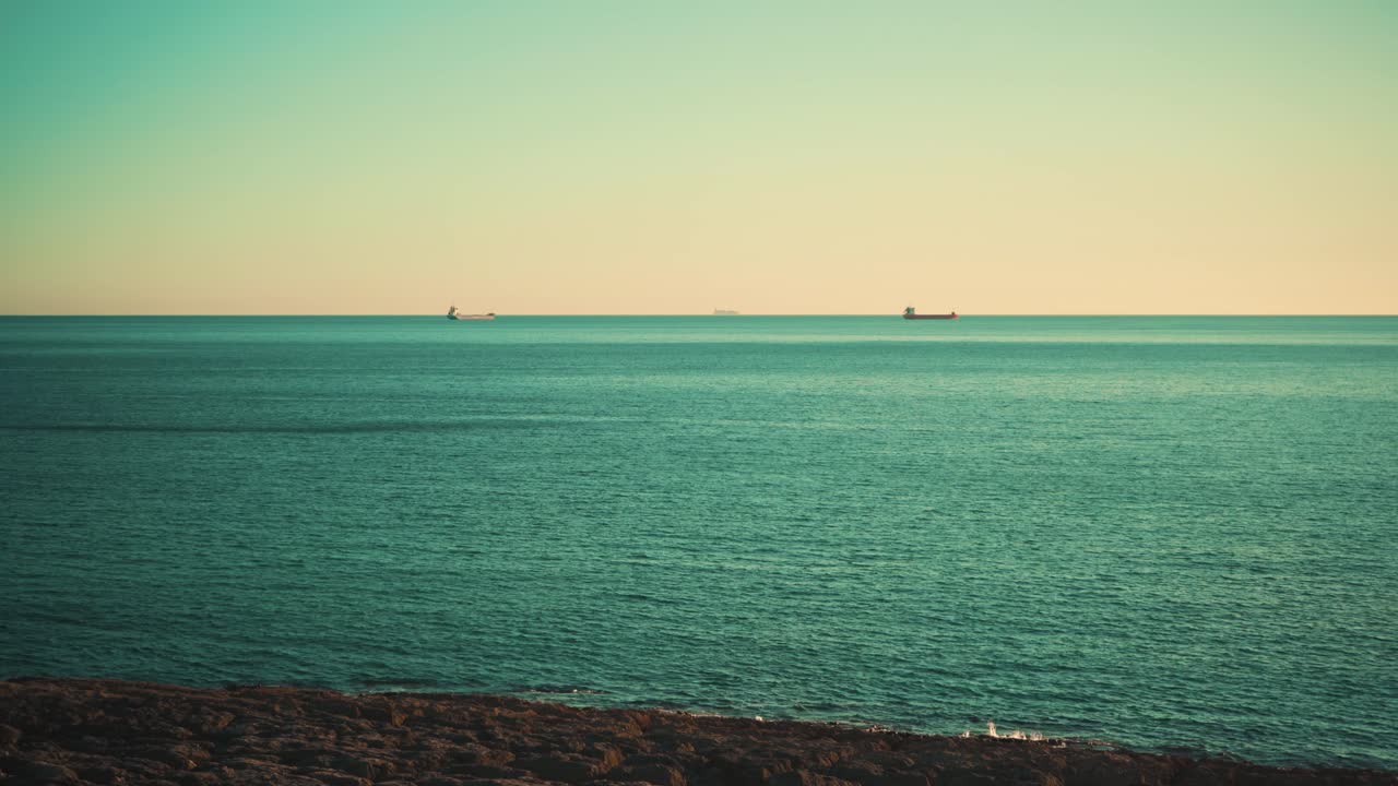 푸른 하늘 4k와 일몰 멀리 화물선과 바다 해안선 절벽 바위
