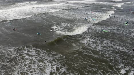 drone shot of a lot of people surfing in ireland