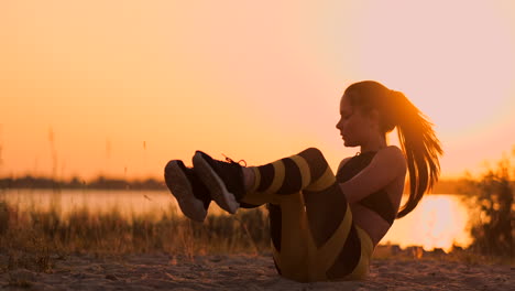 Strong-young-woman-doing-a-medicine-ball-workout-on-sand-dunes.-Athlete-using-rotation-for-fitness-training-at-desert.