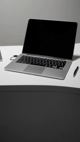 laptop on a white desk with a sign