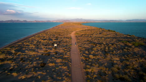 disparo de drones de un auto cruzando las dunas de mogote en baja california sur mexico