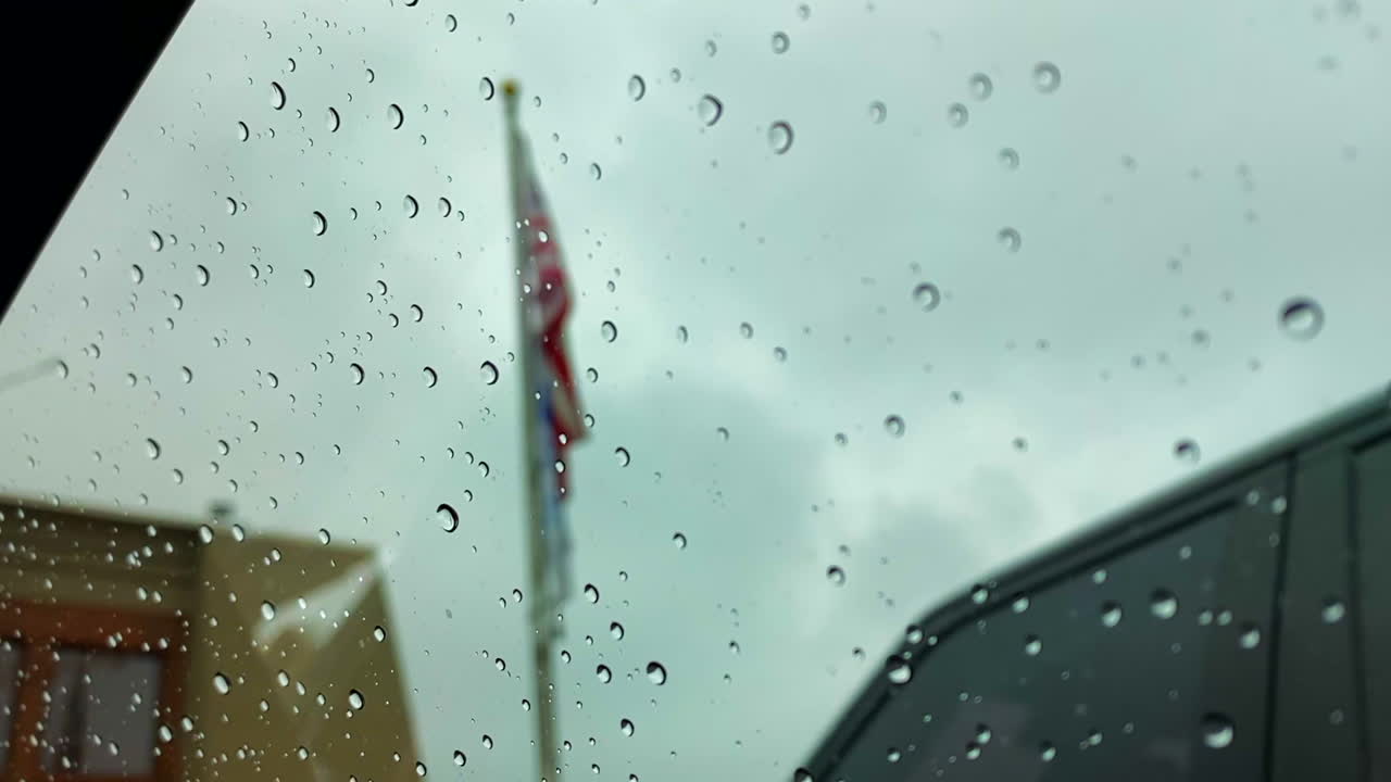 Water drops on a window with an American flag in the background