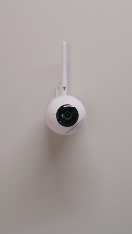 white wireless security camera on a wall