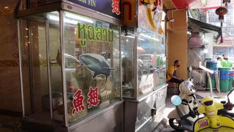 scooter passes by a seafood restaurant storefront