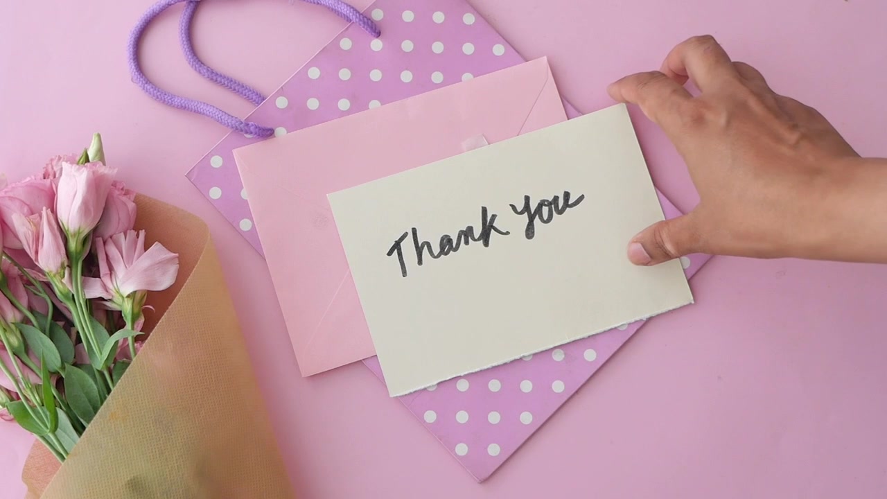 Hand Picking Up Thank You Card From Pink Gift Bag