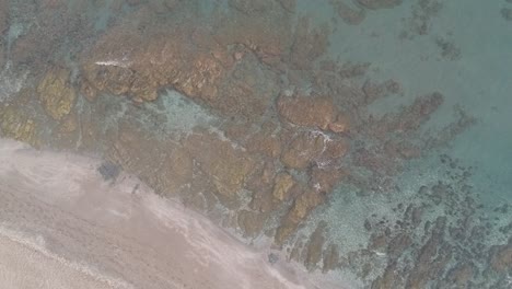 Aerial-view-with-drone-over-a-southern-Spanish-beach-in-Marbella,-Andalusia,-Spain,-calm-waves-on-crystal-clear-water