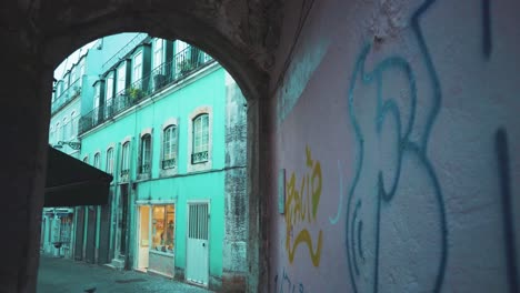 lisbon ancient street tunnel arch with graffiti wall in typical neighborhood