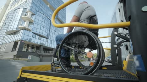 a man in a wheelchair on a lift of a vehicle for people with disabilities. lifting equipment for people with disabilities - man in wheelchair near the vehicle